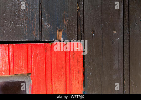 Rosso e nero parete in legno con diversi pattern di colori. Foto Stock