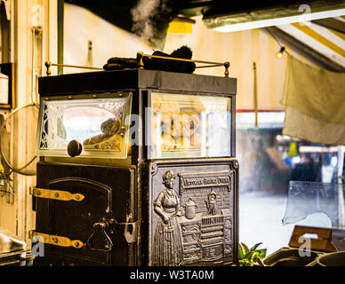 Potato-Kiosk su Vikualien-Markt a München, Germania. L'Agria, una varietà prevalentemente cerosa, cuoce nel forno della Regina Viktoria per otto mesi all'anno. Questo elegante panettiere di patate può ospitare fino a 60 patate. 30 vengono mantenuti caldi, altri 30 nella parte inferiore del forno Foto Stock