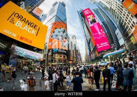 I dipendenti con le loro famiglie e i loro amici a raccogliere il gigantesco schermo video sul Nasdaq stock exchange in Times Square a New York decorato per il debutto della DouYu International Holdings Ltd. offerta pubblica iniziale su Mercoledì, 17 luglio 2019. DouYu è il più grande live-streaming platform in Cina ed è sostenuta da Tencent Holdings Ltd. La valutazione della società a $3,73 miliardi di euro è la più grande IPO cinese nel 2019. (© Richard B. Levine) Foto Stock