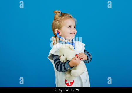 Felice ragazzo in uniforme medico esaminare toy pet con uno stetoscopio Foto Stock