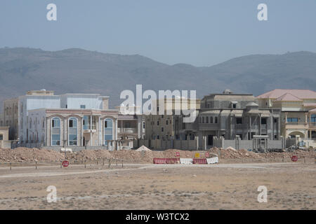 Oman, regione di Dhofar, la città capitale di Salalah. Tipico quartiere nel deserto con la casa nuova costruzione. Foto Stock