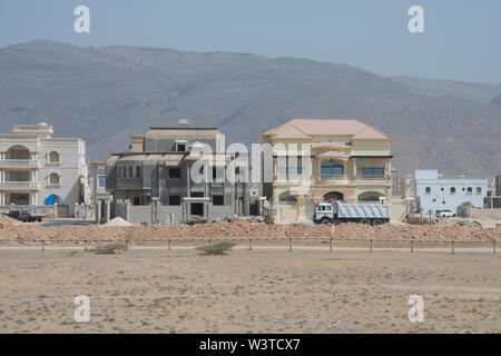 Oman, regione di Dhofar, la città capitale di Salalah. Tipico quartiere nel deserto con la casa nuova costruzione. Foto Stock
