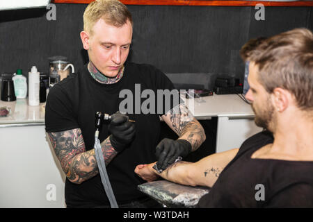 Uomo con tatuaggio lavorando sulla creazione di nuovo tattoo Foto Stock