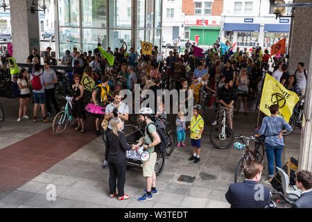 Londra, Regno Unito. 17 Luglio, 2019. Gli attivisti del clima dalla ribellione di estinzione assemblare al di fuori di Hammersmith Town Hall al termine di una massa critica di bicicletta da Waterloo Millennium verde sul terzo giorno della loro 'Summer uprising'. Gli attivisti hanno tre richieste di Hammersmith e Fulham consiglio: per far passare la proposta di dichiarare una emergenza climatica; per mantenere Hammersmith Bridge chiusa per veicoli; e impegnarsi a safer itinerari in bicicletta. Credito: Mark Kerrison/Alamy Live News Foto Stock