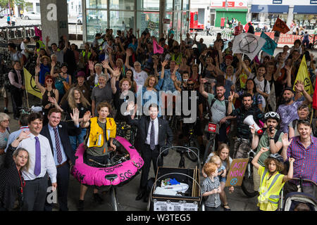 Londra, Regno Unito. 17 Luglio, 2019. Gli attivisti del clima dalla ribellione di estinzione assemblare al di fuori di Hammersmith Town Hall al termine di una massa critica di bicicletta da Waterloo Millennium verde sul terzo giorno della loro 'Summer uprising'. Gli attivisti hanno tre richieste di Hammersmith e Fulham consiglio: per far passare la proposta di dichiarare una emergenza climatica; per mantenere Hammersmith Bridge chiusa per veicoli; e impegnarsi a safer itinerari in bicicletta. Credito: Mark Kerrison/Alamy Live News Foto Stock