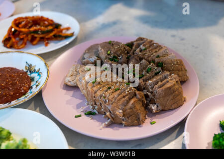 Bossam, bollito di maiale mangiati con una salsa salata e avvolto in verdi, bossam kimchi, cibo Coreano Foto Stock