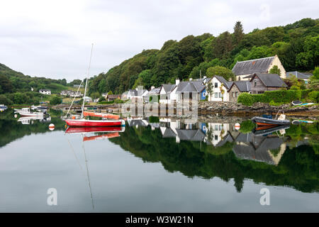 La mattina presto riflessi colorati di barche al di ancoraggio sul Loch Sween al pittoresco villaggio di pescatori di Tayvallich in Argyle e Bute, Scotland, Regno Unito Foto Stock