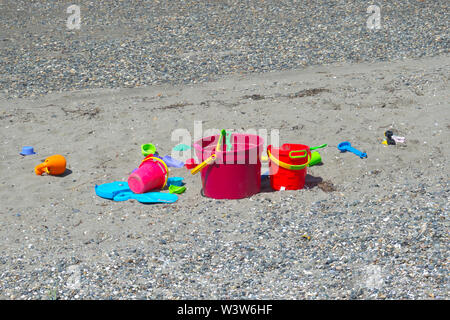 Per bambini in plastica colorata secchi sulla spiaggia. Spiaggia a mezzaluna, B. C., Canada Foto Stock