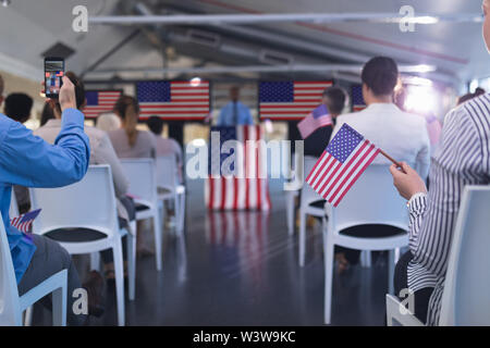 La gente di affari sventola una bandiera americana nel seminario di business Foto Stock