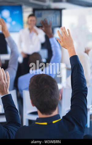 La gente di affari ad alzare la mano nel seminario di business Foto Stock