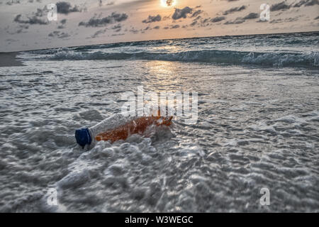 Questa singolare mostra fotografica di una bottiglia di plastica dal mare della spiaggia di Maldive Foto Stock