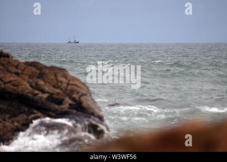 Un piccolo peschereccio vele passato Charleston sulla costa ovest Foto Stock