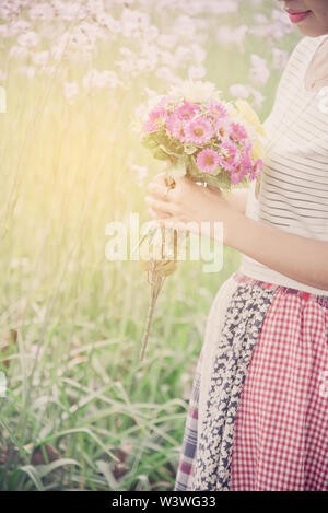 Felice fiorista femmina con il mazzo di fiori colorati. Sorridente giovane donna azienda floreale. Foto Stock