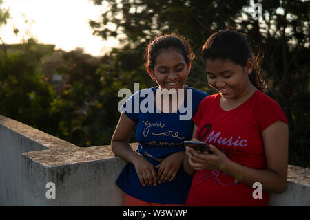 La teenager fare divertire con lo smartphone in all'aperto Foto Stock