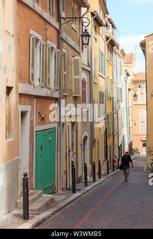 Marseille, Francia - 8 Settembre 2015: Un uomo cammina su una ripida strada. La vecchia area portuale ha molti vecchi edifici. Foto Stock