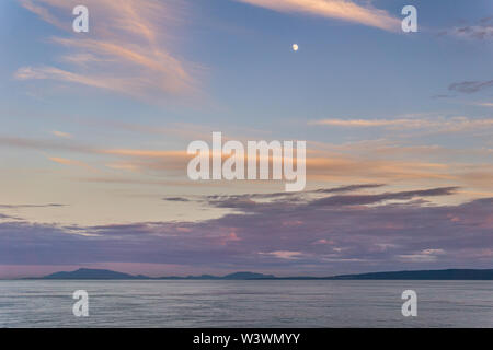 nuvoloso tramonto e luna nello stretto della Georgia tra Vancouver e Victoria. Foto Stock