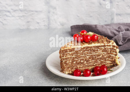 Torta di sottili frittelle di cioccolato e crema di pistacchio con rosse bacche Ribes Foto Stock