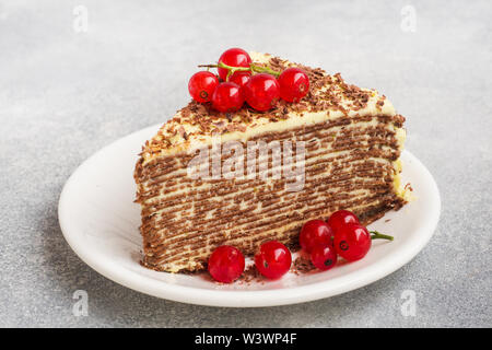 Torta di sottili frittelle di cioccolato e crema di pistacchio con rosse bacche Ribes Foto Stock