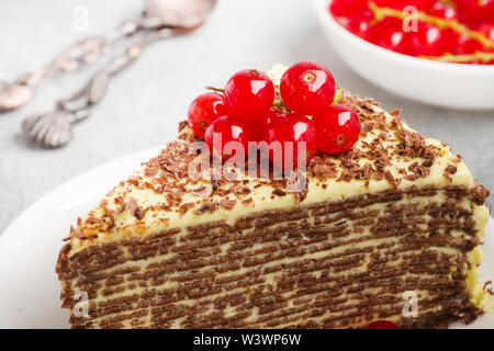 Torta di sottili frittelle di cioccolato e crema di pistacchio con rosse bacche Ribes Foto Stock