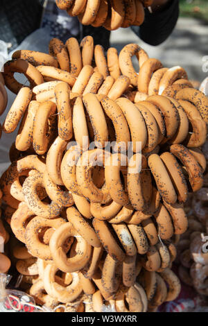 Un sacco di round biscotti secchi con un foro nel mezzo. Essiccamento bagel con semi di papavero in una fiera in una giornata di sole. Un mazzetto di sushka presso il mercato è per Foto Stock