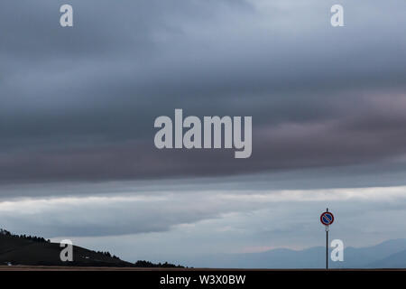 Cartello stradale contro un moody sfondo cielo con grandi nuvole Foto Stock