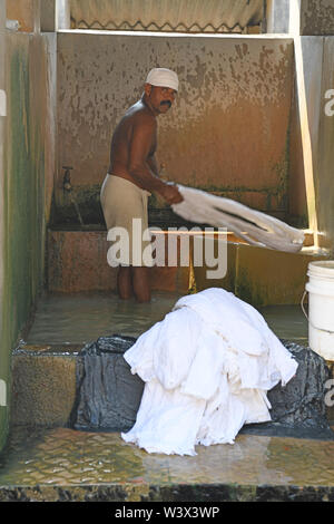 Uomo indiano il lavaggio della biancheria e lenzuola a Dhobi khana lavanderia pubblica a Kochi (Cochin) Kerala, India Foto Stock