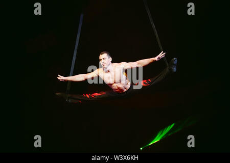 Acrobat esegue un trucco difficile nel circus. Foto Stock