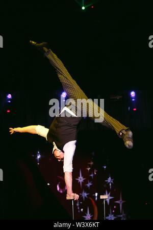 Acrobat esegue un trucco difficile nel circus. Foto Stock