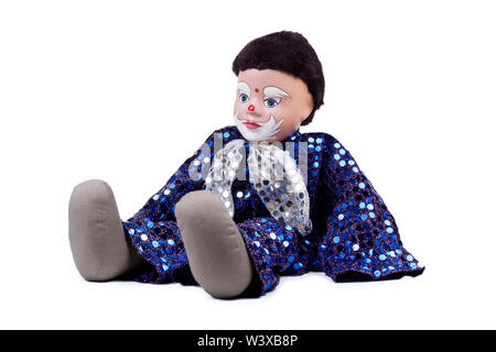 Una piccola nera e blu ragazzo dai capelli clown come bambola lucido con paillettes e una prua sul collo, seduto in posa. Isolato su bianco, fantoccio dettagliata Foto Stock