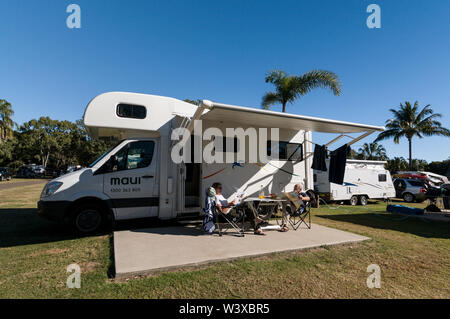Un giovane su una vacanza caravan, avente la prima colazione durante il caldo australiano sole invernale a Agnes Water Beach caravan e campeggio nel Queensland, Foto Stock