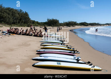 Un gruppo di giovani di wouldee surfers avente una lezione di surf su Agnes Water surf beach a Agnes Water nel Queensland, Australia Agnes Water è un sma Foto Stock