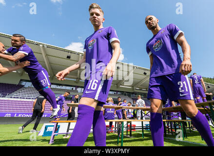 Aue, Germania. 18 Luglio, 2019. Soccer seconda Bundesliga: Fototermin FC Erzgebirge Aue per la stagione 2019/20 nell'Sparkassen-Erzgebirsgstadion. Lettore Testroet Pascal (l) salta dalla birra tabella dopo la sessione di foto, mentre i suoi compagni di squadra Erik Majetschak (M) e Malcolm Cacutalua passanti. Credito: Robert Michael/dpa-Zentralbild/dpa/Alamy Live News Foto Stock