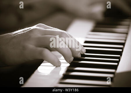 Immagine in bianco e nero delle mani di un musicista di talento che suona una bella melodia sul sintetizzatore, premendo i tasti con le dita. Questo è Foto Stock