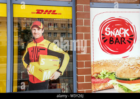 Delivery man DHL, un annuncio sul negozio DHL Office, snack Bar in via Dresden Germania Foto Stock