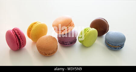 Macarons colori pastello con crema di cioccolato su sfondo bianco, vista ravvicinata con i dettagli, banner Foto Stock