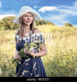 Stile di vita ritratto ambientale. Modello lettone con fiori. Foto Stock
