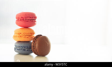 Macarons colori pastello impilati su sfondo bianco, vista ravvicinata con i dettagli, spazio di copia Foto Stock