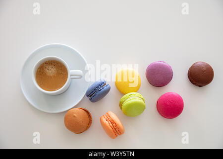 Macarons e caffè esresso sul tavolo bianco, blur sullo sfondo, vista ravvicinata con i dettagli Foto Stock