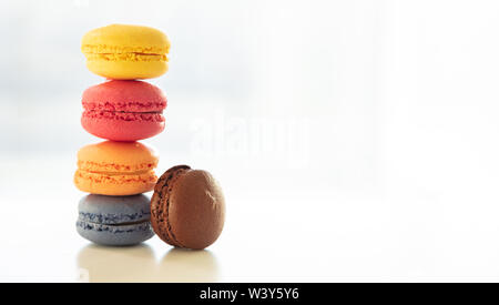 Macarons colori pastello impilati su sfondo bianco, vista ravvicinata con i dettagli, spazio di copia Foto Stock