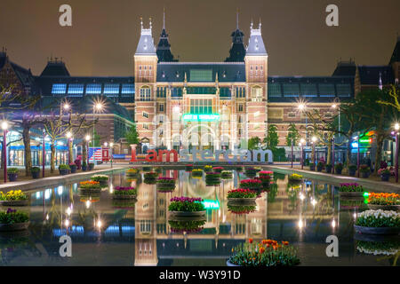 Rijksmuesum e Museumplein illuminiated di notte, Amsterdam, Olanda Settentrionale, Paesi Bassi Foto Stock