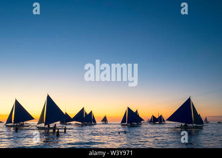 Barche a vela al tramonto sulla spiaggia bianca, Boracay Island, Aklan Provincia, Western Visayas, Filippine Foto Stock