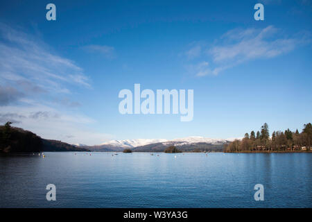 La neve clad Fairfield Horseshoe sopra Ambleside dalla riva del lago Bowness-on-Windermere in una luminosa giornata invernale il Lake District Cumbria Inghilterra England Foto Stock