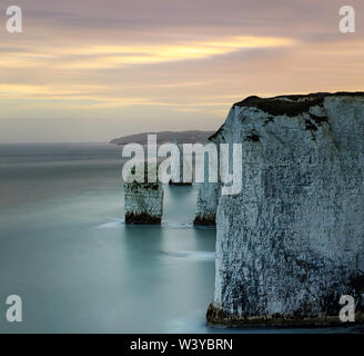 Le pile nei pressi della vecchia Harry rocce al tramonto, l'estremità orientale della Jurassic Coast.Handfast punto, Dorset, Inghilterra. Fotografie con lunghi tempi di esposizione Foto Stock