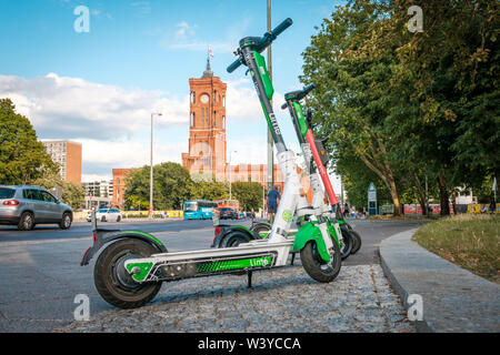 Berlino, Germania - Giugno, 2019: elettrica e scooter , escooter o e-scooter dell'autostop azienda LIME sul marciapiede in Berlino, Germania Foto Stock