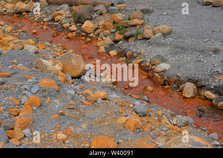 Sorgente di acqua primavera con alto contenuto di Ferrum che dà un arrugginito di colore arancione al dzhily su valle nella Repubblica Kabardino-Balkar nel Nord Caucaso Distretto federale della Russia. Foto Stock
