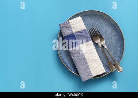 Blu piastra vuota, a scacchi igienico e le forche sul pastello blu sullo sfondo. Vista superiore, piana, laici spazio copia
