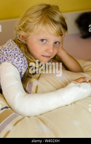 Hurt ragazza bionda con mano rotto nella fascia Foto Stock