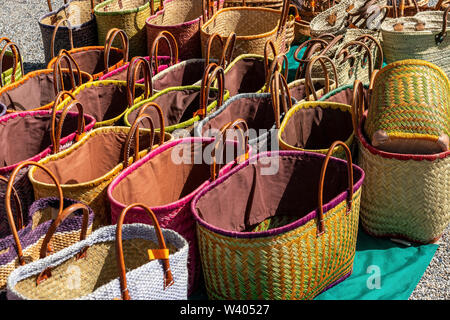 Un display di colorate a mano cestini di vimini per la vendita in un mercato francese adatto per il trasporto di shopping Foto Stock