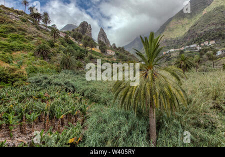 San Pedro - rocce vulcaniche Montagne Gemelle, monumento naturale di La Hermigua a La Gomera. Giornata di sole - tipica area rurale, piantagioni di banane, frutteti Foto Stock