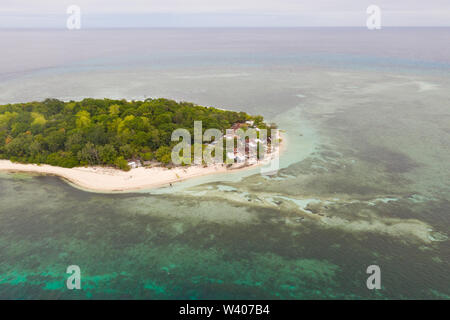 Round isola tropicale con spiaggia di sabbia bianca, vista dall'alto. Isola di Mantigue, Filippine.piccola isola abitata circondata da una barriera corallina. Foto Stock